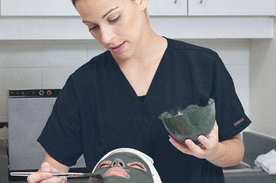 student applying a face mask to a client