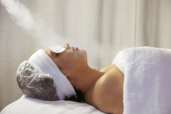 Woman having her face steamed for a facial